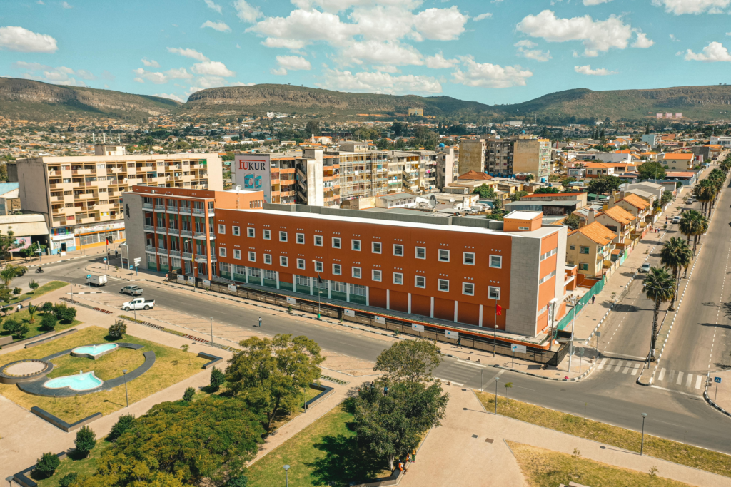 Explore the vibrant cityscape of Lubango, Angola, with mountains and urban architecture.