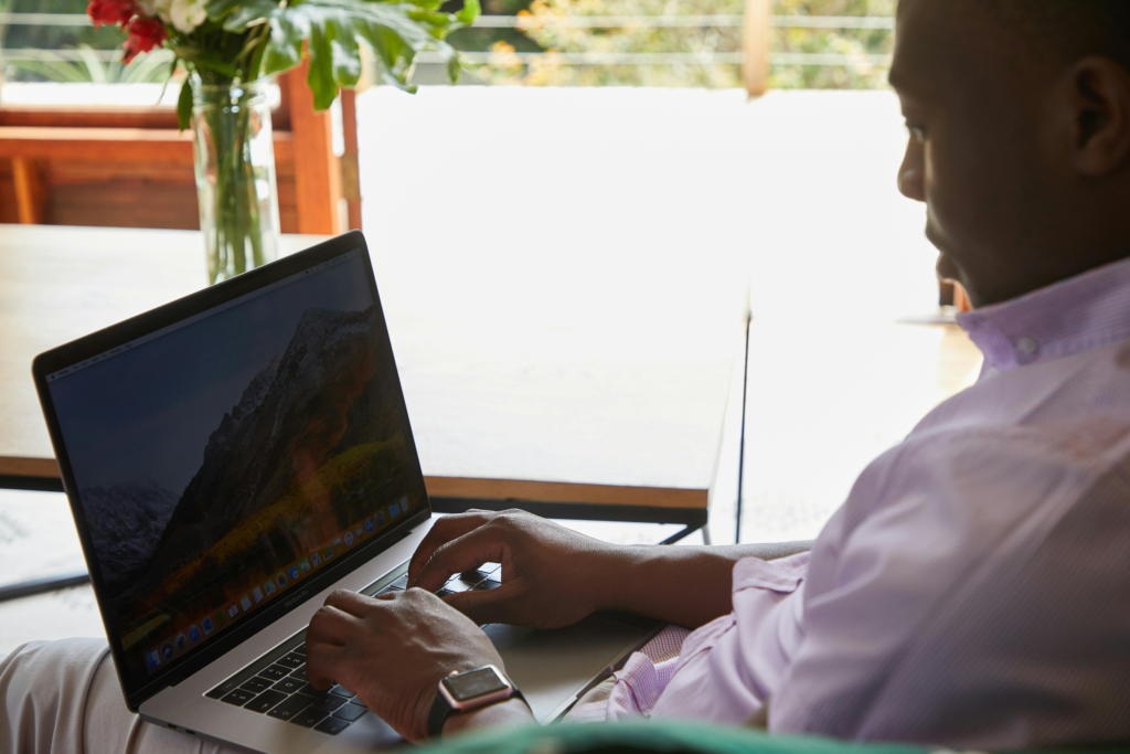 Confident man using laptop indoors, showcasing modern technology and comfort.